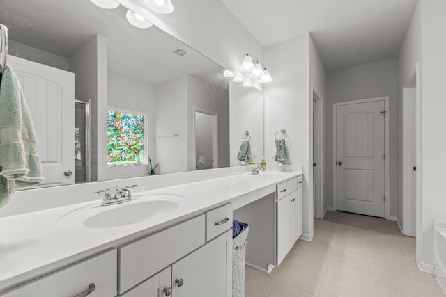 bathroom with tile patterned flooring, double vanity, a shower with door, visible vents, and a sink