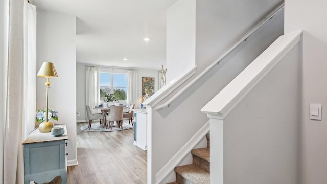 stairs with baseboards, recessed lighting, and wood finished floors