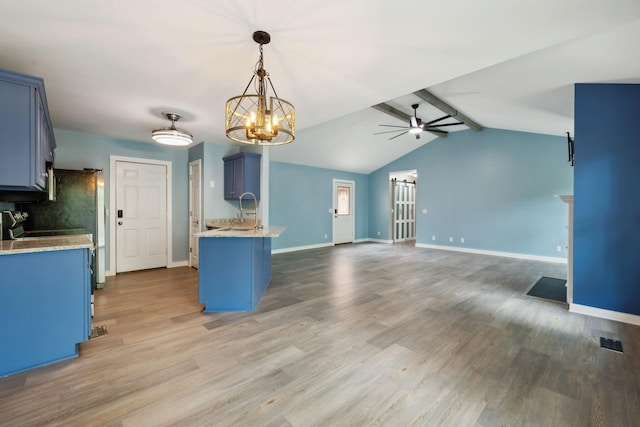 kitchen with baseboards, a sink, ceiling fan with notable chandelier, and blue cabinetry