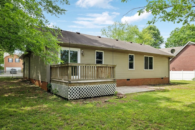 back of property with fence, a deck, crawl space, a patio area, and a lawn