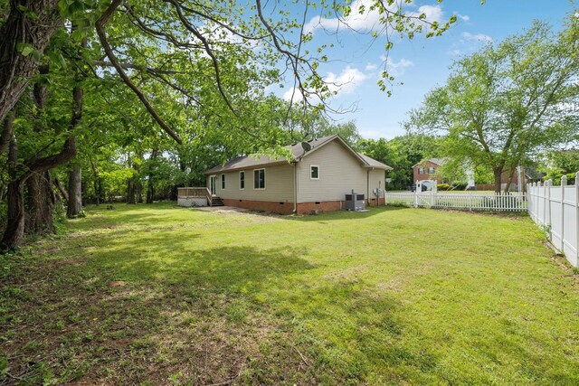 view of yard with central AC and a fenced backyard
