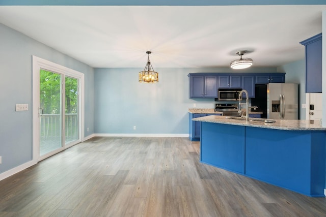 kitchen featuring a sink, light wood-style flooring, appliances with stainless steel finishes, and blue cabinetry