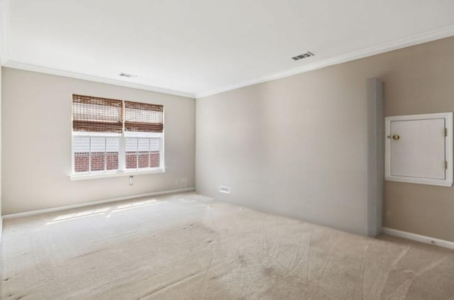 spare room featuring crown molding, carpet floors, and visible vents