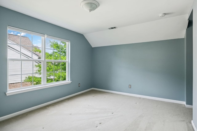 additional living space with baseboards, carpet flooring, lofted ceiling, and visible vents