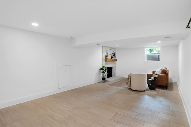 interior space featuring recessed lighting, light wood-style flooring, a brick fireplace, and visible vents