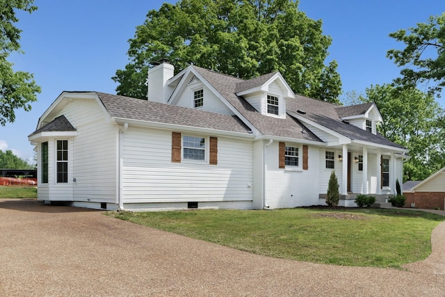 cape cod home with crawl space, a front yard, a chimney, and roof with shingles