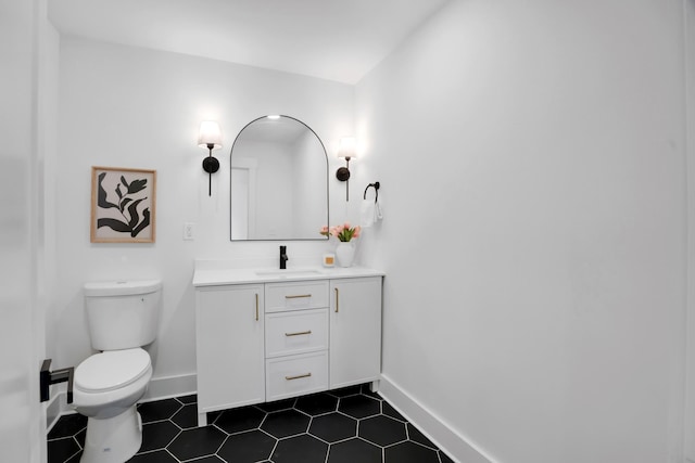 bathroom with tile patterned flooring, baseboards, toilet, and vanity