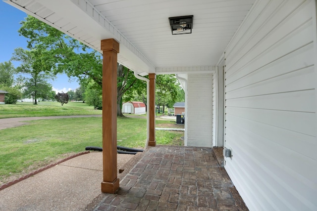 view of patio featuring an outdoor structure and a storage unit