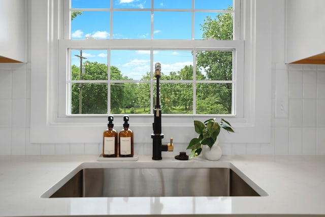 room details featuring light countertops, white cabinetry, and a sink