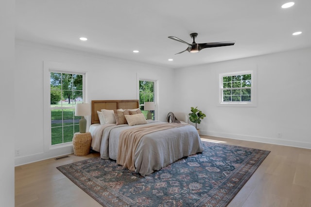 bedroom with multiple windows, recessed lighting, wood finished floors, and visible vents