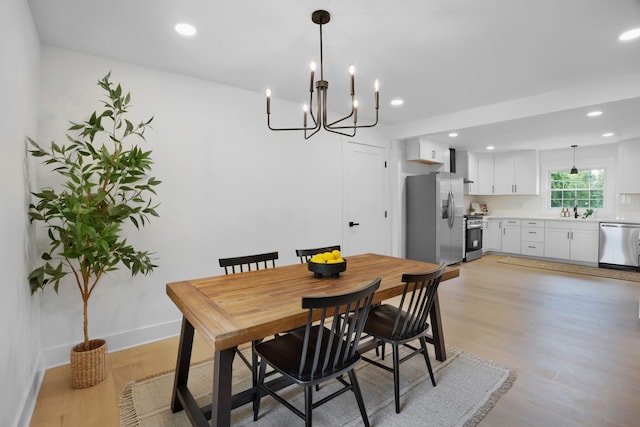 dining area with recessed lighting, light wood finished floors, baseboards, and a chandelier