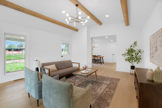 living room with an inviting chandelier, lofted ceiling with beams, light wood finished floors, and a wealth of natural light