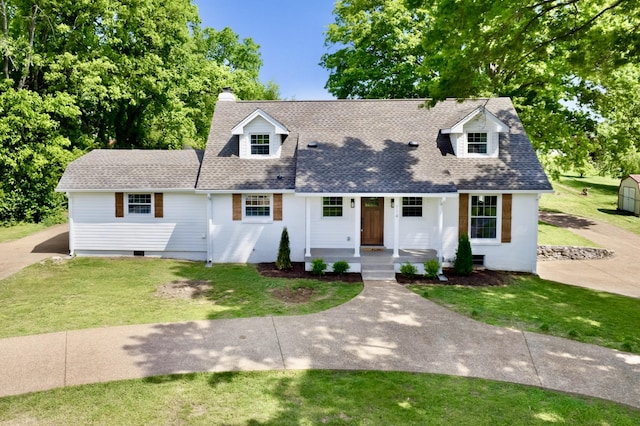 cape cod-style house with a porch, a shingled roof, a front lawn, and a chimney