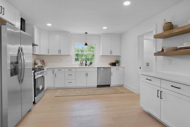kitchen with recessed lighting, light wood-type flooring, white cabinetry, a sink, and stainless steel appliances