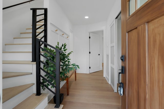 entrance foyer with recessed lighting, light wood-type flooring, and stairs