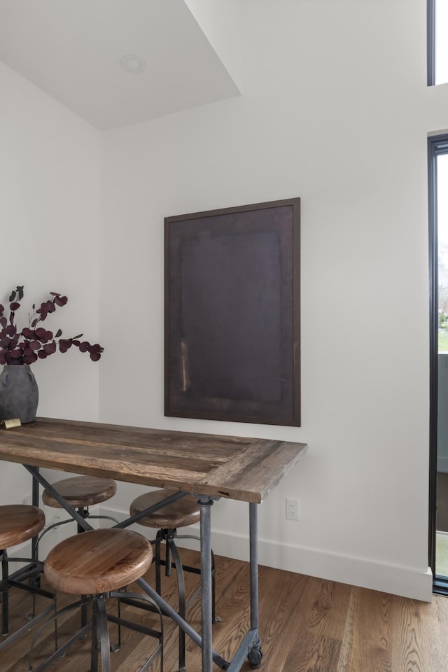 dining space with baseboards and wood finished floors