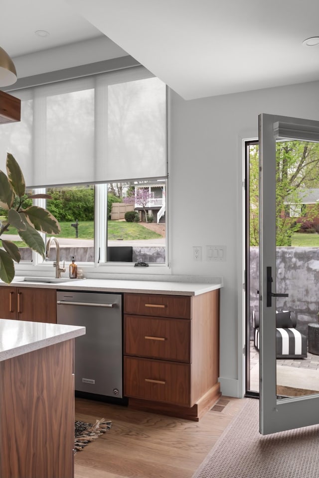 bar featuring stainless steel dishwasher, a sink, and wood finished floors