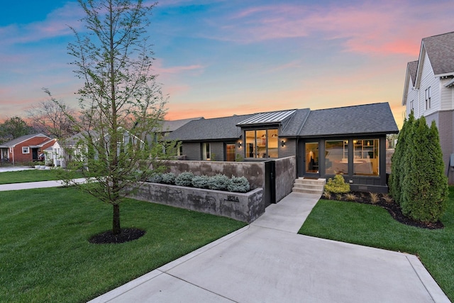 prairie-style house with a front lawn and roof with shingles
