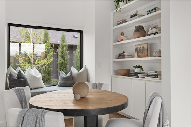 dining space featuring built in shelves, wood finished floors, and a wealth of natural light