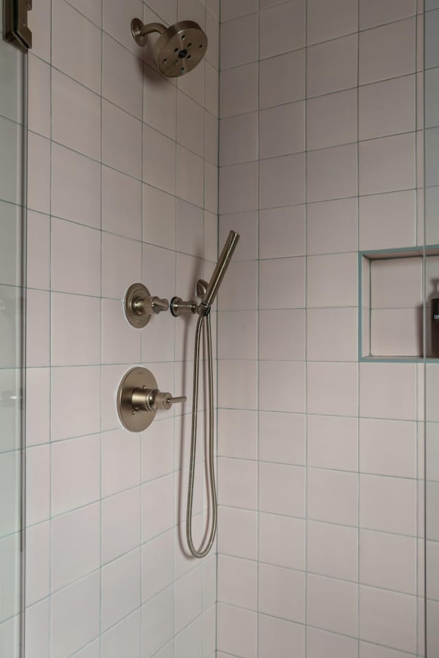 interior details featuring a tile shower