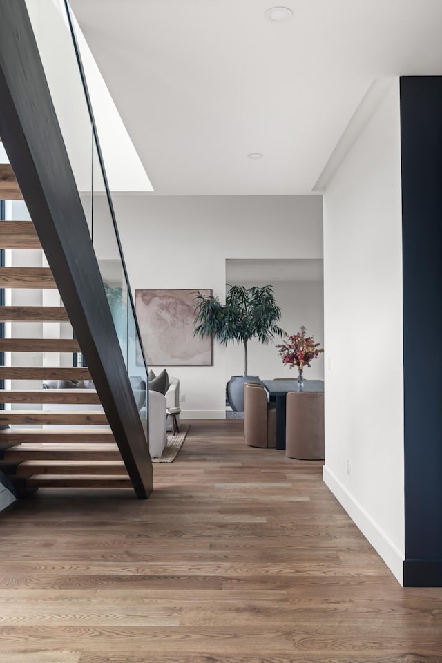 stairway with baseboards, recessed lighting, and wood finished floors