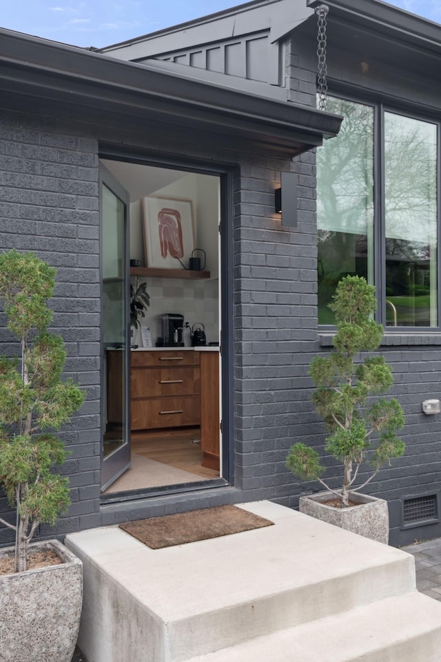 doorway to property with brick siding