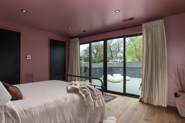 bedroom with recessed lighting, visible vents, access to exterior, and wood finished floors
