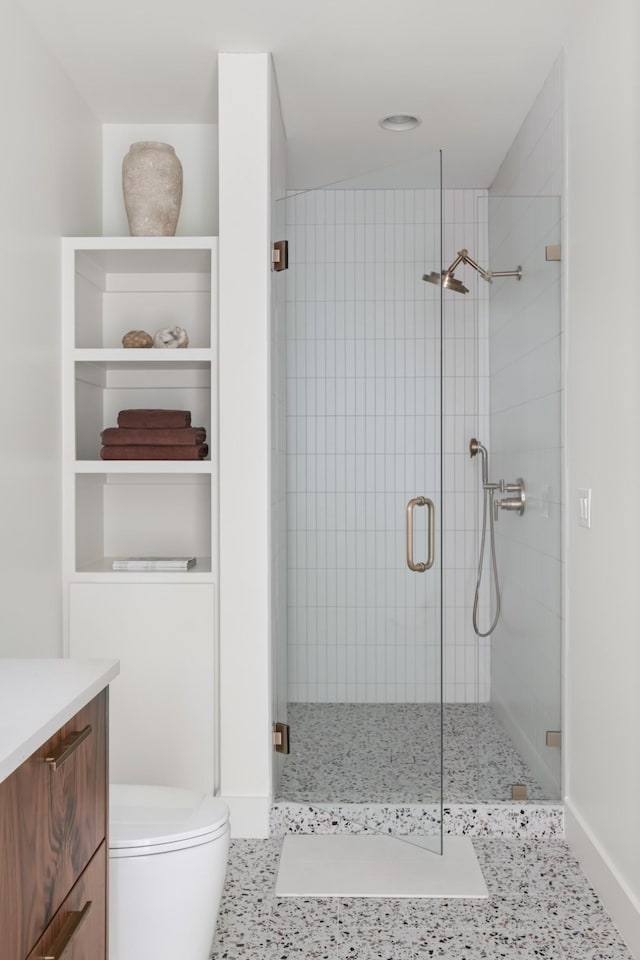 bathroom featuring vanity, a shower stall, and toilet