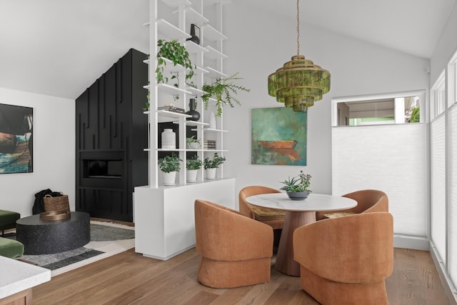 dining space with wood finished floors and lofted ceiling