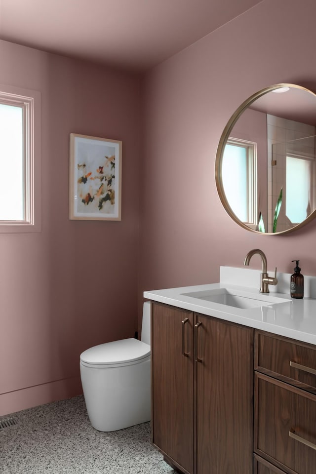 bathroom featuring vanity, speckled floor, and toilet