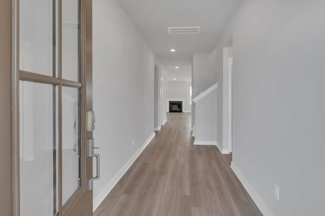 hall featuring visible vents, recessed lighting, baseboards, and wood finished floors