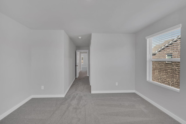 spare room with baseboards and carpet