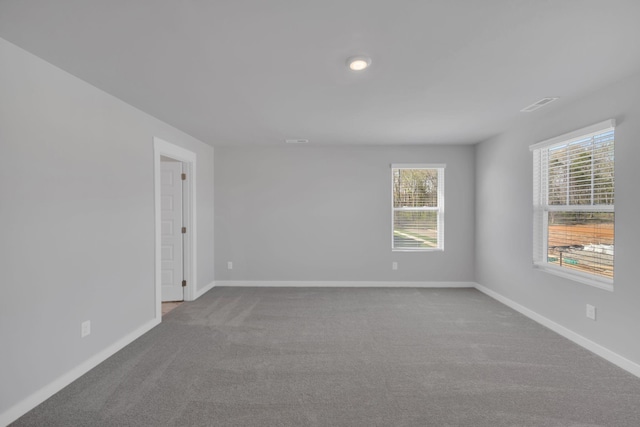 unfurnished room featuring baseboards, carpet, and a healthy amount of sunlight