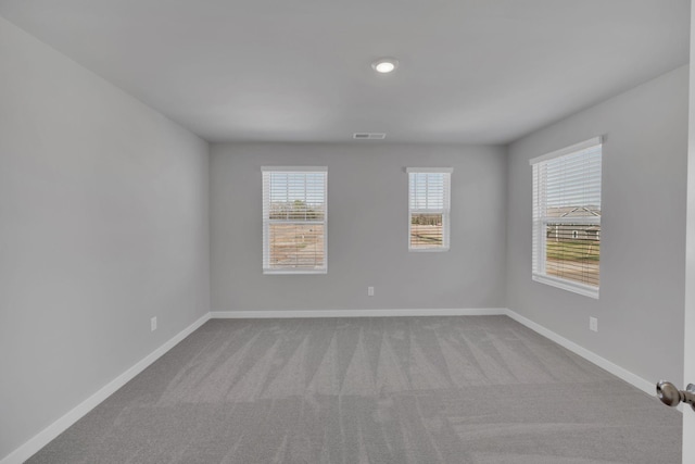 carpeted spare room with baseboards and visible vents