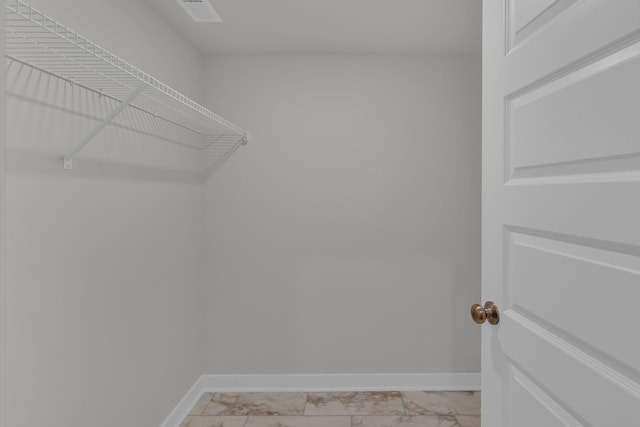 spacious closet featuring visible vents and marble finish floor