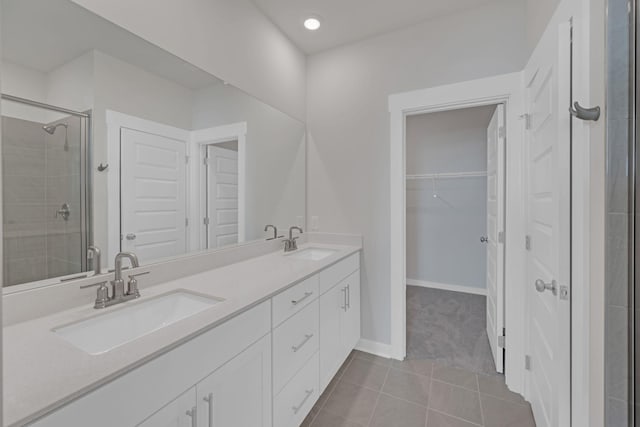 bathroom with tile patterned floors, a shower stall, and a sink