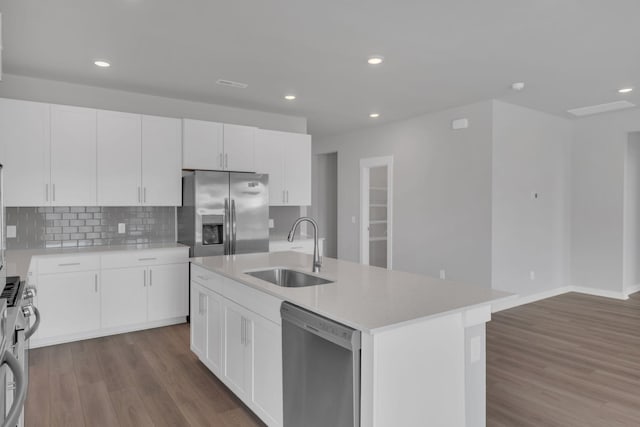 kitchen featuring a sink, appliances with stainless steel finishes, backsplash, and dark wood-style flooring