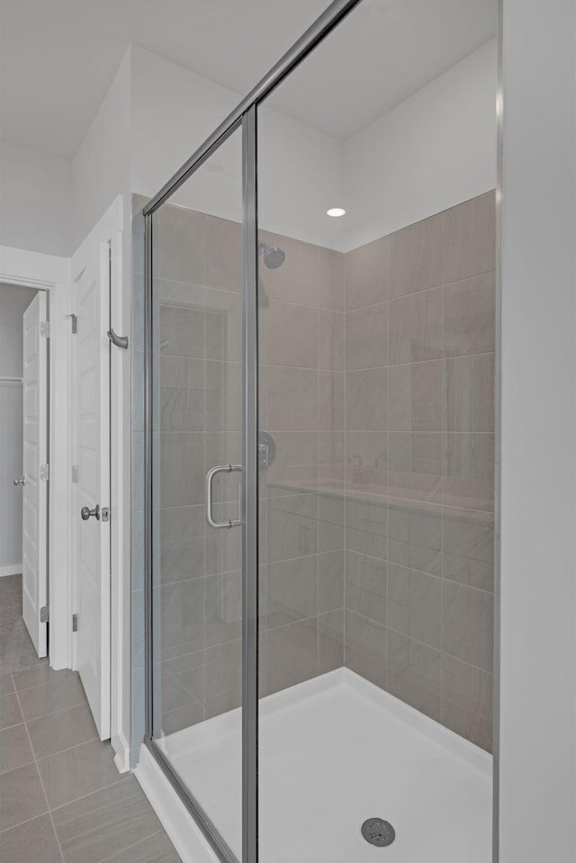 full bath with tile patterned flooring and a shower stall