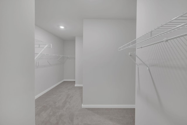 walk in closet featuring light colored carpet