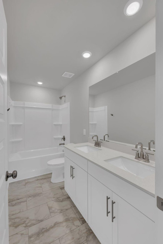 bathroom featuring a sink, toilet,  shower combination, and marble finish floor