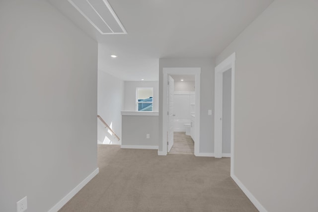 hall featuring light colored carpet, recessed lighting, baseboards, and an upstairs landing