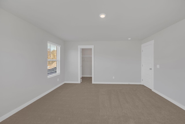 empty room with baseboards and carpet
