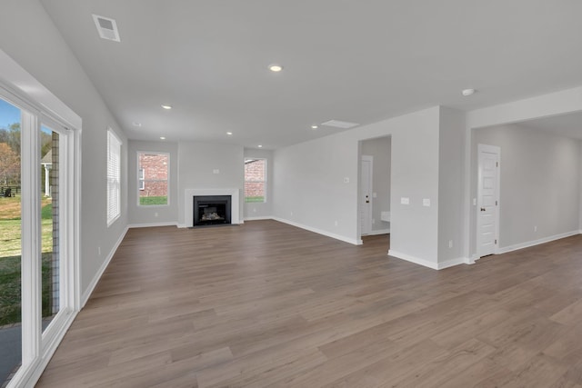 unfurnished living room with recessed lighting, baseboards, visible vents, and wood finished floors