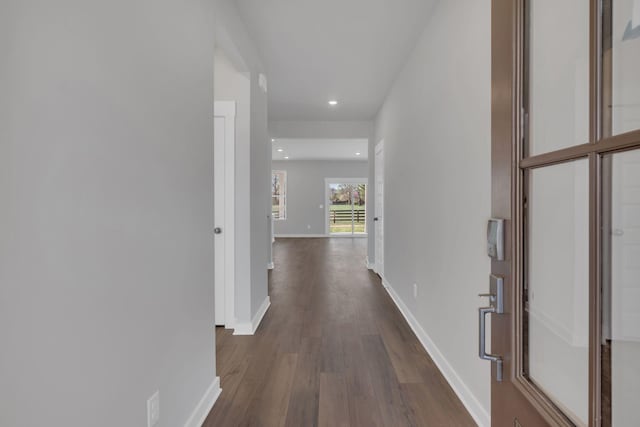 hall with dark wood-type flooring, recessed lighting, and baseboards