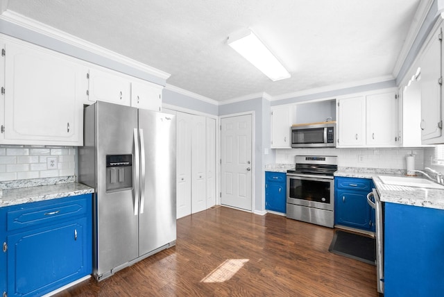 kitchen featuring a sink, appliances with stainless steel finishes, tasteful backsplash, and blue cabinets
