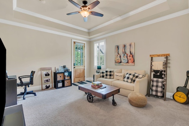 living area with crown molding, a ceiling fan, a tray ceiling, and carpet