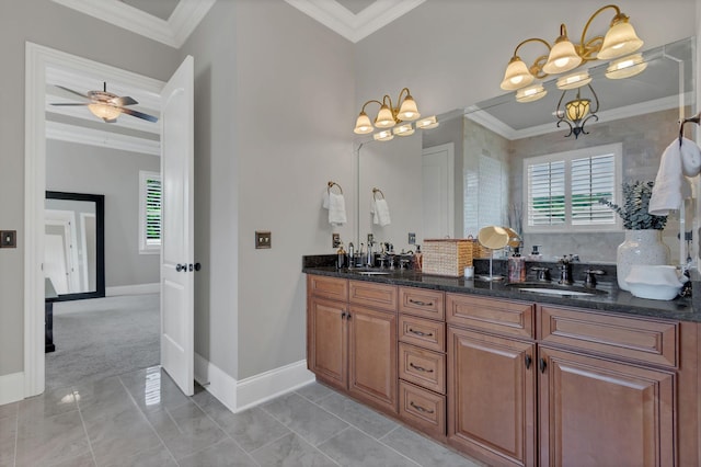 bathroom with a sink, baseboards, crown molding, and double vanity