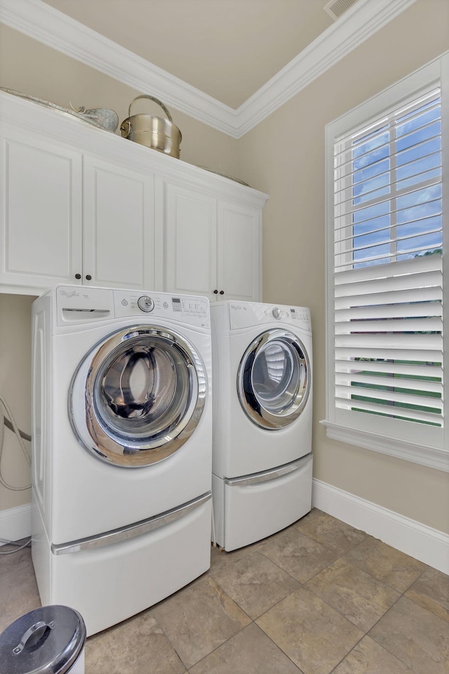 washroom featuring stone finish flooring, crown molding, cabinet space, baseboards, and washer and dryer