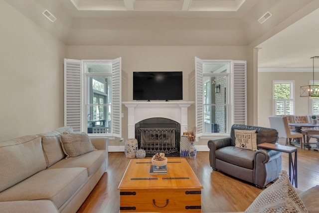 living area featuring visible vents, wood finished floors, a notable chandelier, and a fireplace