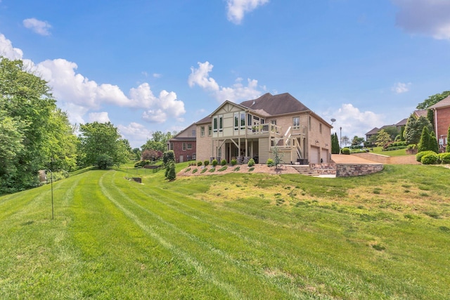 back of house with an attached garage, a lawn, stairway, and a deck